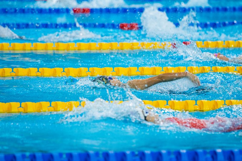 Swimmers racing through pool lanes